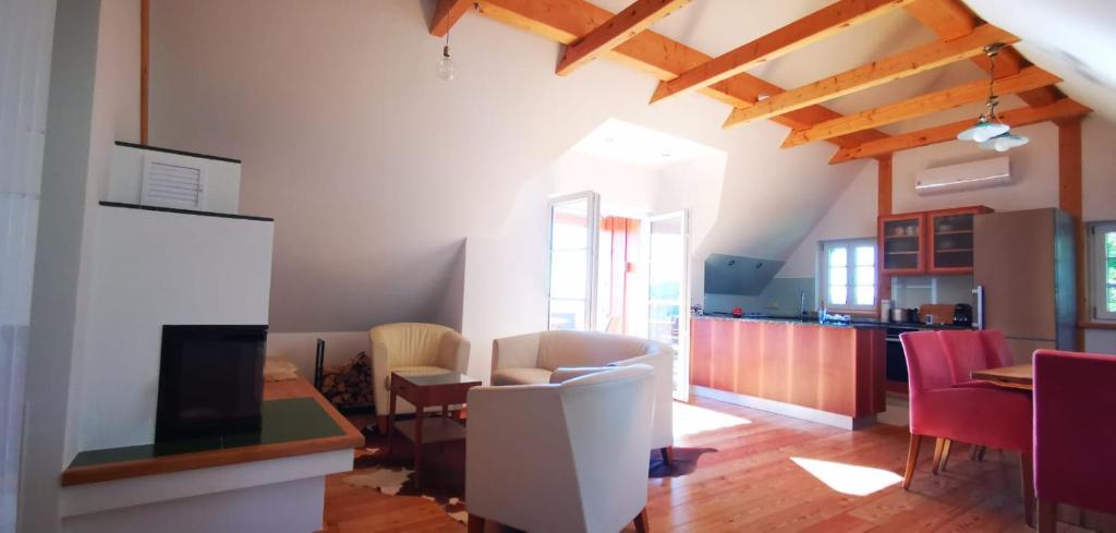 uma sala de estar com mesa e cadeiras e uma cozinha em Chalet-Südsteiermark - traumhafte Aussicht, Infinity Pool, Privatsphäre, Klima und de-luxe Ausstattung em Schwanberg