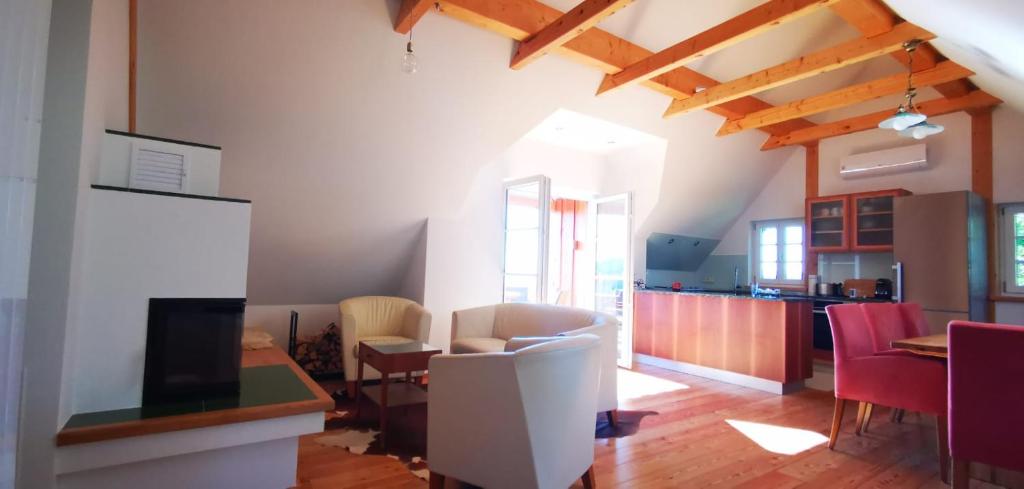 a living room with a table and chairs and a kitchen at Chalet-Südsteiermark - traumhafte Aussicht, Infinity Pool, Privatsphäre, Klima und de-luxe Ausstattung in Schwanberg