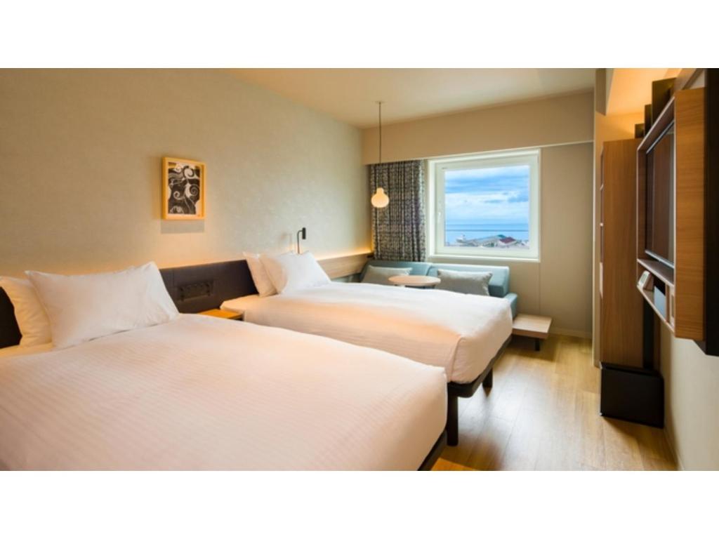 a hotel room with two beds and a window at GRIDS Premium Hotel Otaru - Vacation STAY 68534v in Otaru