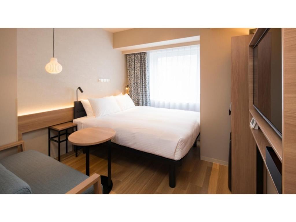a hotel room with a bed and a table at GRIDS Premium Hotel Otaru - Vacation STAY 68544v in Otaru