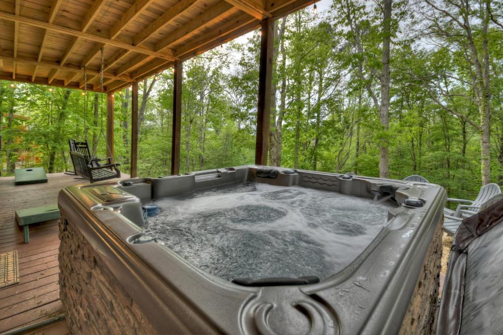 einen Whirlpool auf der hinteren Veranda eines Hauses in der Unterkunft ENJOY & have some FUN! Cabin with Game Room & Hot Tub in Blue Ridge
