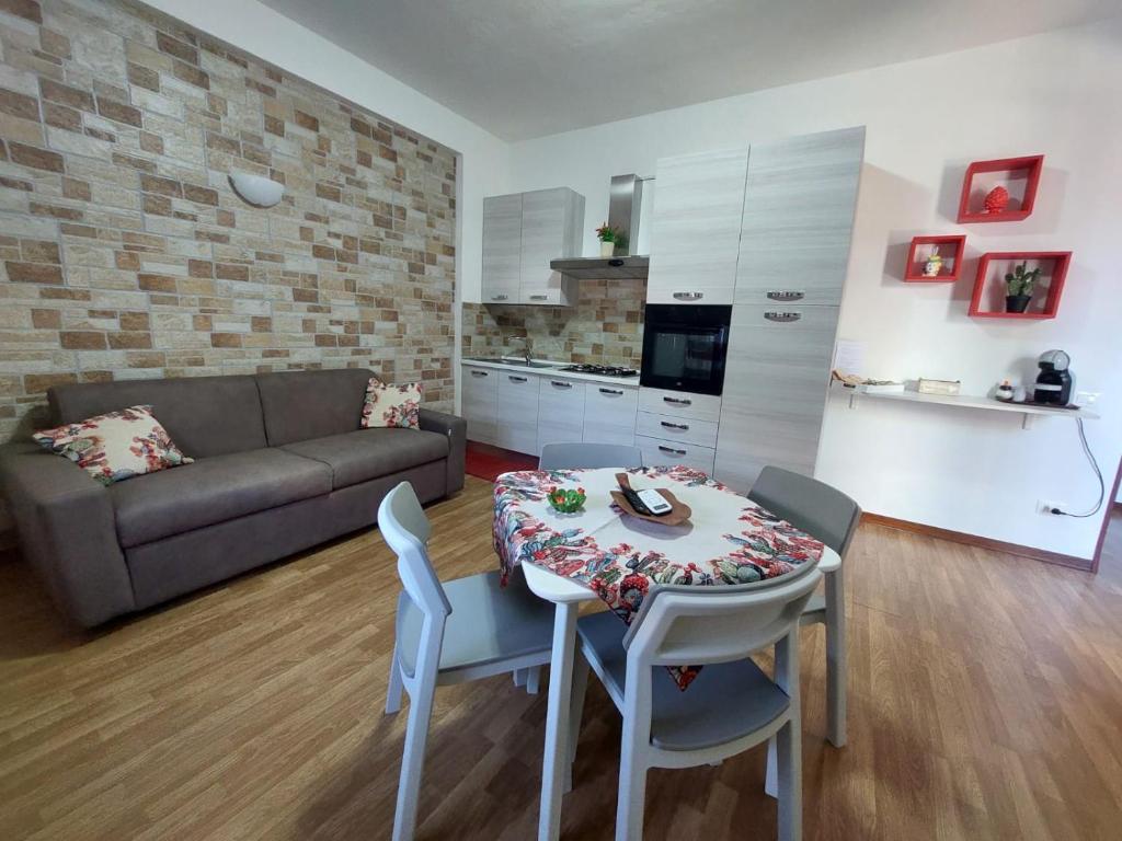 uma sala de estar com uma mesa e um sofá em Kalisa Home, B&B e Casa Vacanza Palermo em Capaci