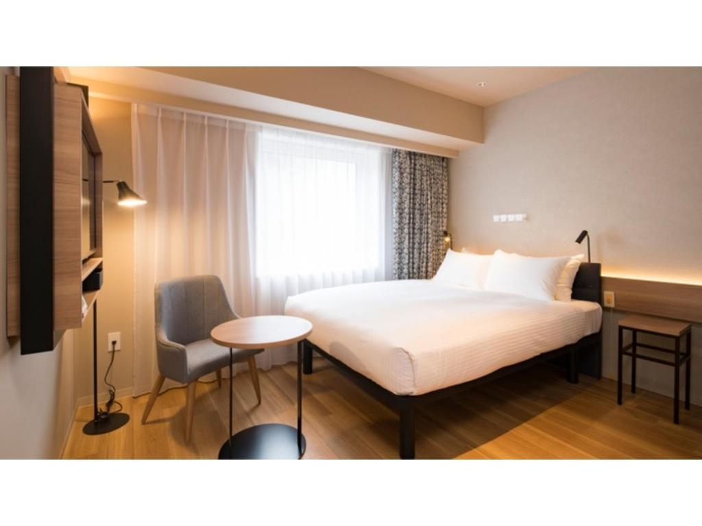 a hotel room with a bed and a table and a chair at GRIDS Premium Hotel Otaru - Vacation STAY 68535v in Otaru