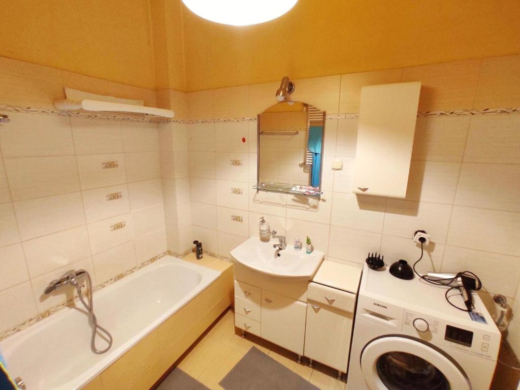 La salle de bains est pourvue d'une baignoire, d'un lavabo et d'un lave-linge. dans l'établissement Room in Old Town Krakow, à Cracovie