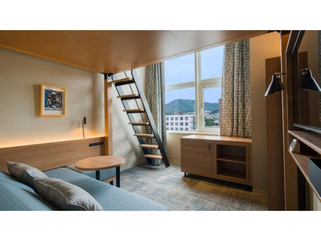 a bedroom with a bed with a ladder and a window at GRIDS Premium Hotel Otaru - Vacation STAY 68539v in Otaru