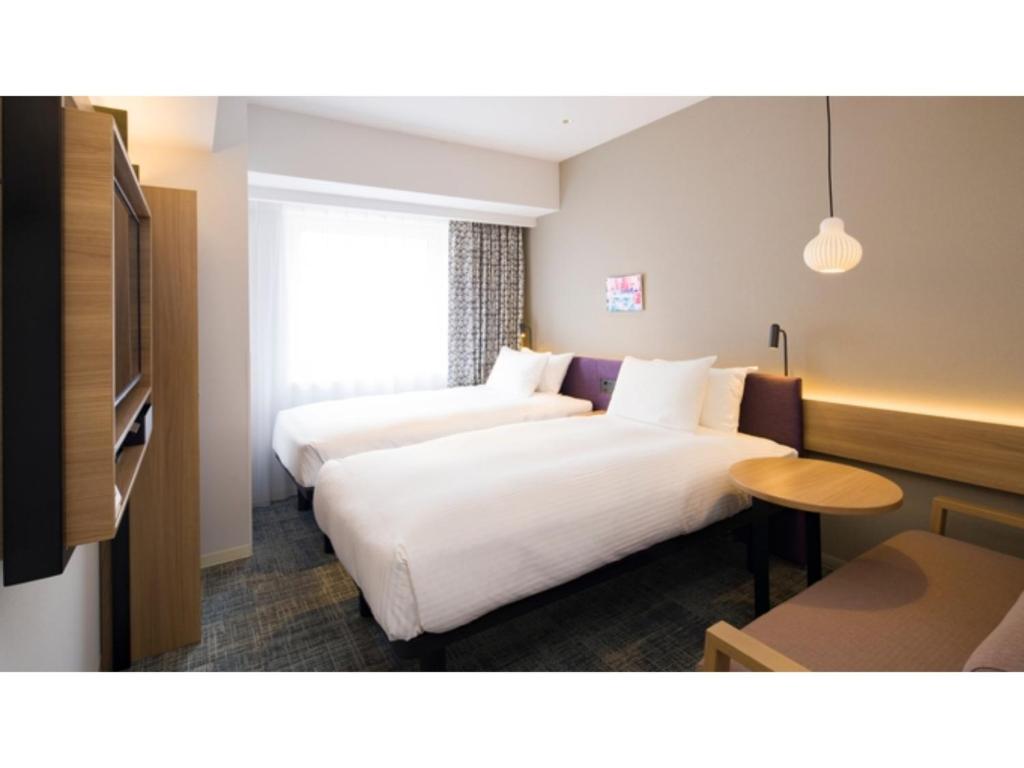 Habitación de hotel con 2 camas y mesa en GRIDS Premium Hotel Otaru - Vacation STAY 68538v, en Otaru