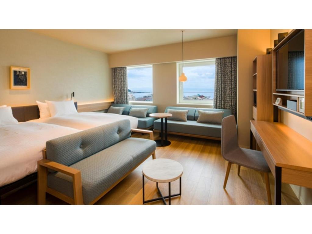 een hotelkamer met een groot bed en een bank bij GRIDS Premium Hotel Otaru - Vacation STAY 68532v in Otaru