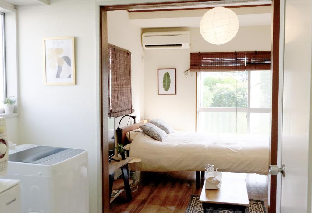 a small bedroom with a bed and a window at Daiichi Mitsumi Corporation - Vacation STAY 15349 in Musashino