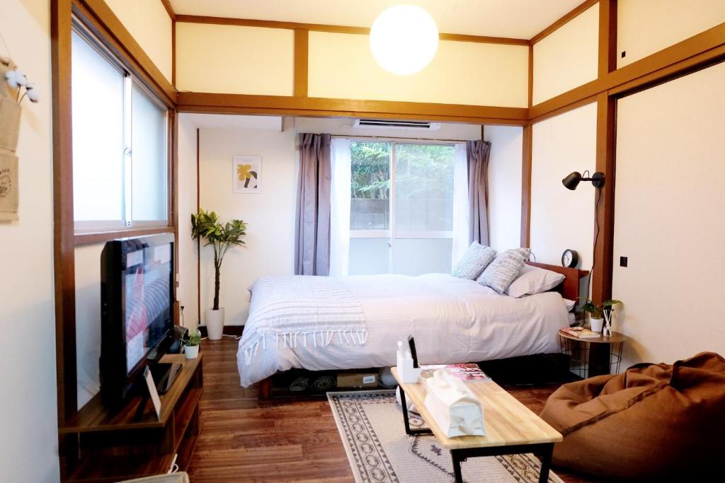 a bedroom with a bed and a tv and a window at Daiichi Mitsumi Corporation - Vacation STAY 15356 in Musashino