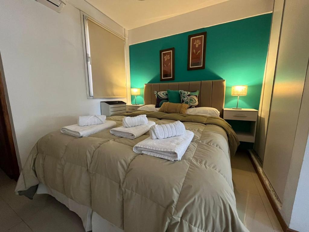 1 dormitorio con 1 cama grande y paredes verdes en Alvarado Apart en Bahía Blanca