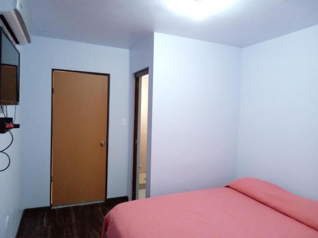 1 dormitorio con cama y puerta marrón en Hospedaje JrzConsulado en Ciudad Juárez