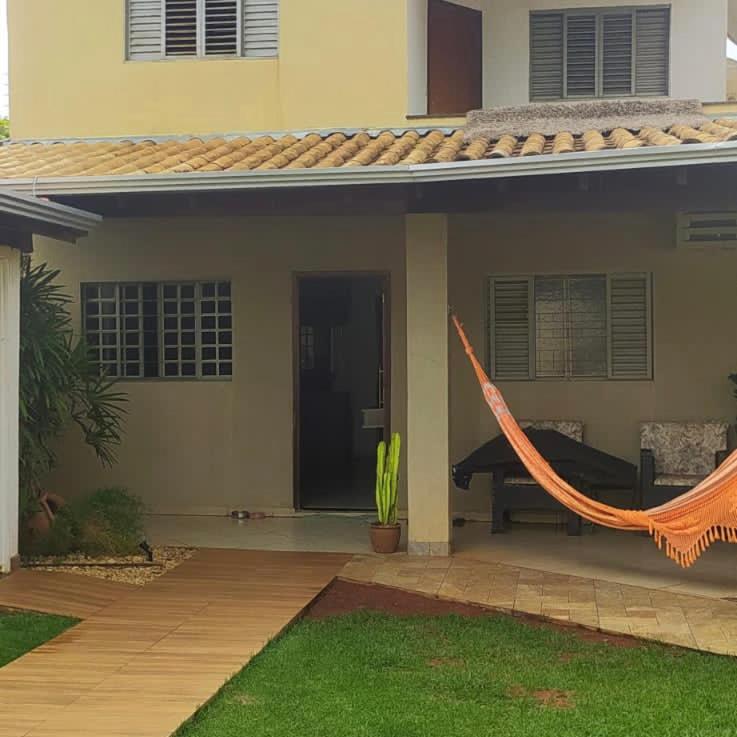 ein Haus mit einer orangefarbenen Hängematte davor in der Unterkunft Sobrado lindo in Campo Grande