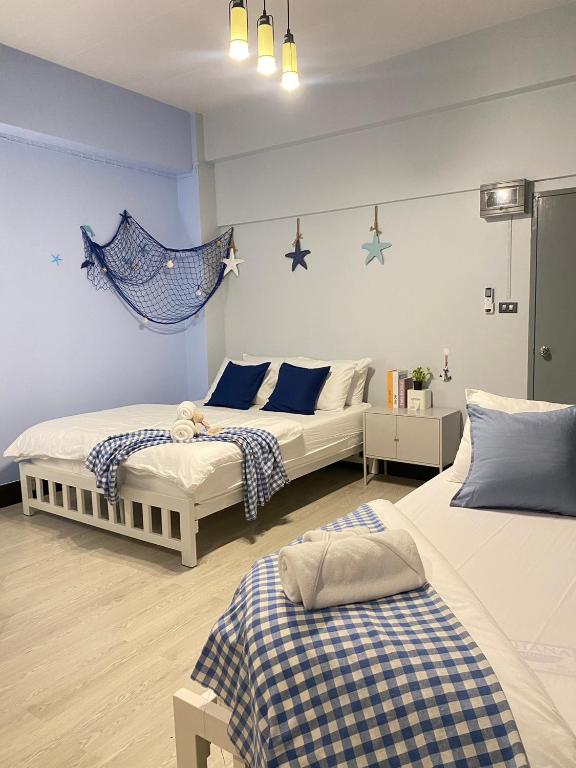 two beds in a room with blue and white at Triple J hotel Trang in Trang