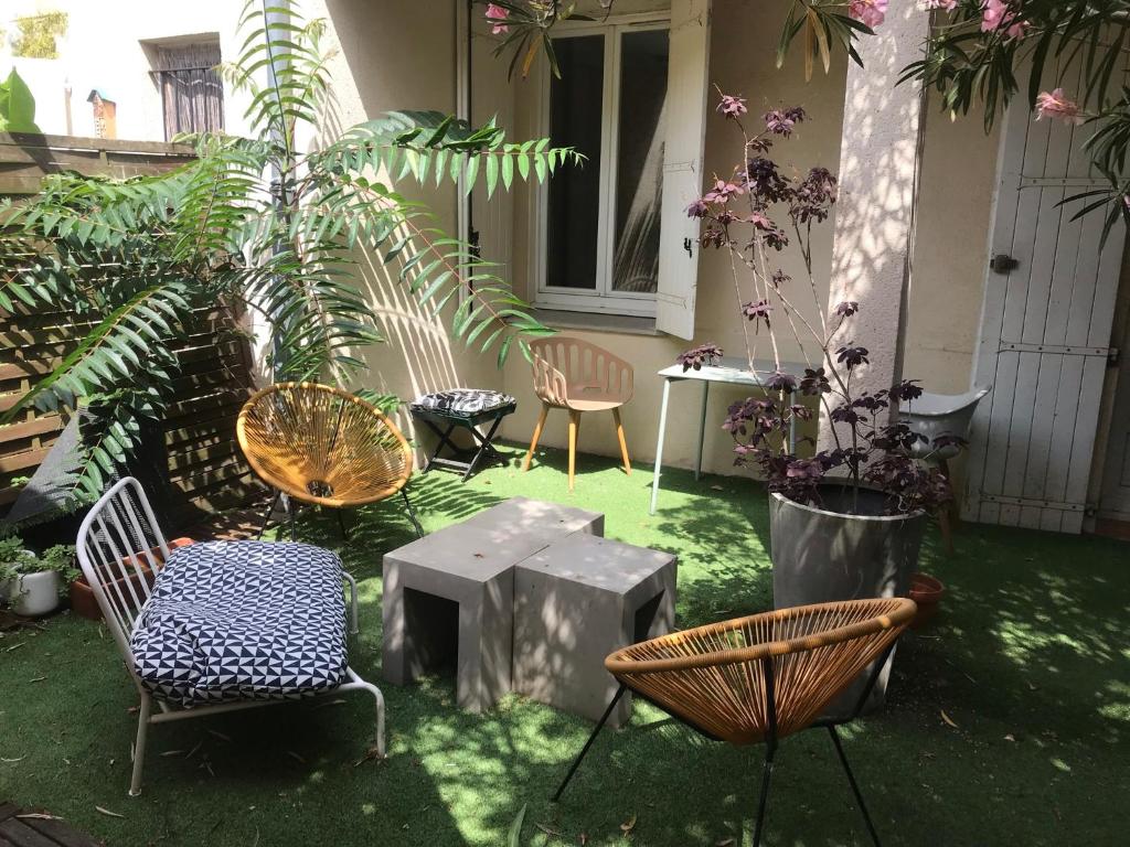 un patio con sillas, mesas y plantas en Le Patio, en Burdeos
