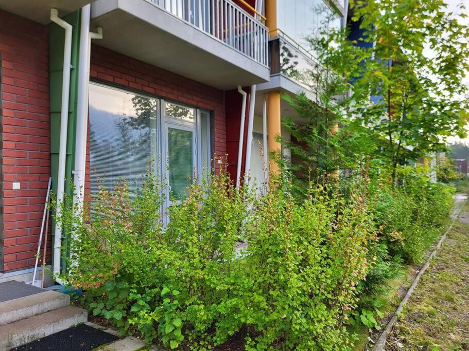 una casa con arbustos delante de una ventana en Modern apartment near Helsinki airport, en Vantaa