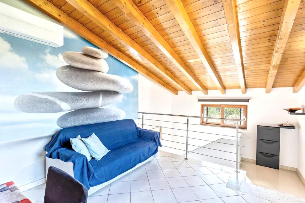 um quarto com um sofá azul e uma pilha de pedras em 2 bedrooms apartement with furnished terrace and wifi at Verona em Verona