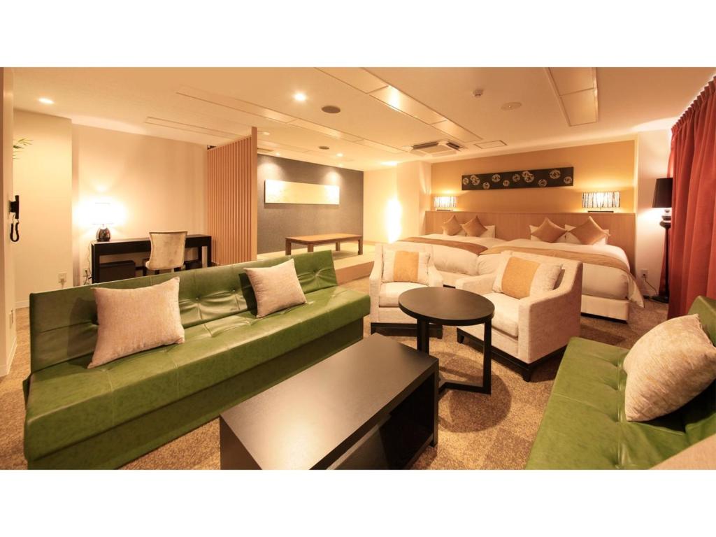 ein Wohnzimmer mit einem Sofa und einem Bett in der Unterkunft Centurion Hotel Villa Suite Fukui Ekimae - Vacation STAY 34650v in Fukui