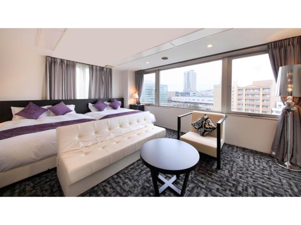 Centurion Hotel Villa Suite Fukui Ekimae - Vacation STAY 34532v في فوكوي: غرفة في الفندق مع سرير كبير مع وسائد أرجوانية