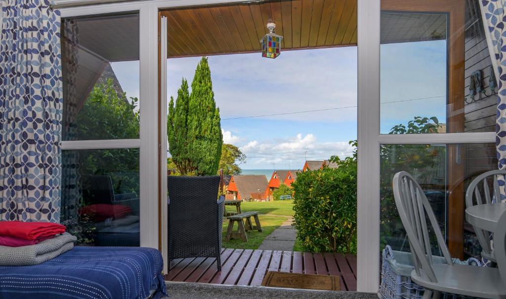 a screened in porch with a view of a yard at Escape to a Clifftop Chalet with pool and tennis onsite - 38 Kingsdown Park in Kingsdown