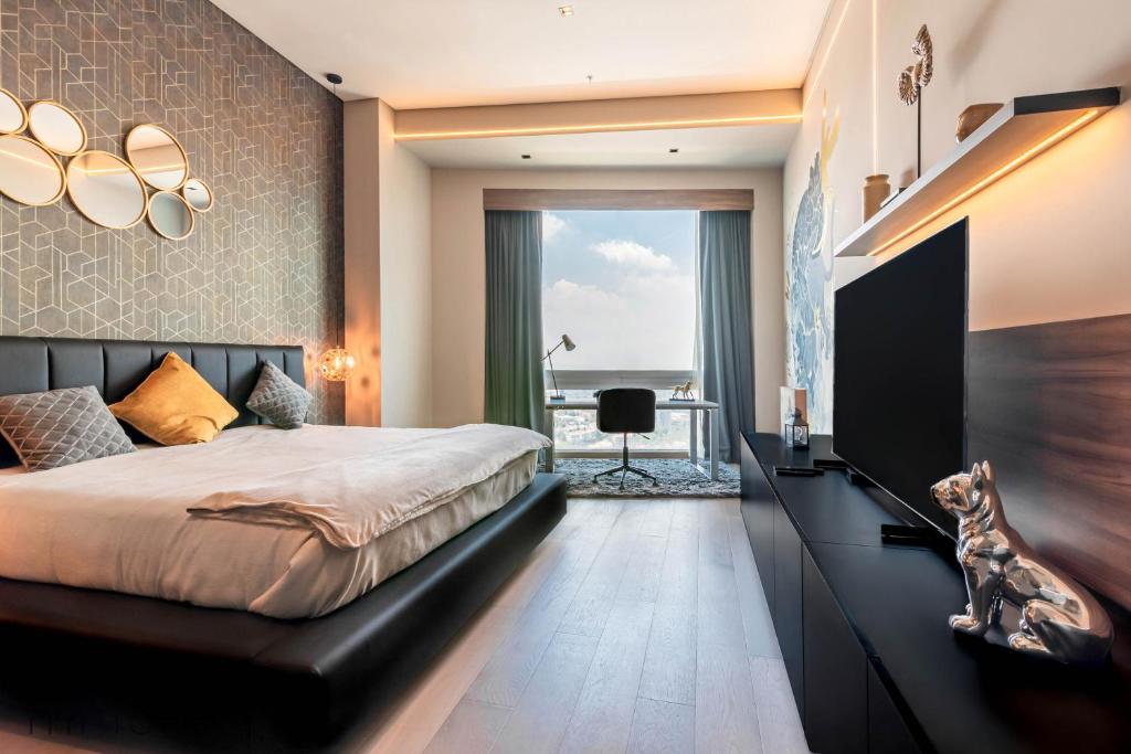 um quarto com uma cama grande e uma televisão em Luxurious Studio w/ City Views From the 46th Floor em Cidade do México