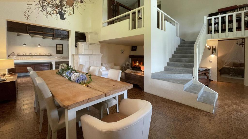 a dining room with a table and chairs and a staircase at VILLA SELVA - Piemonte in Agrate Conturbia