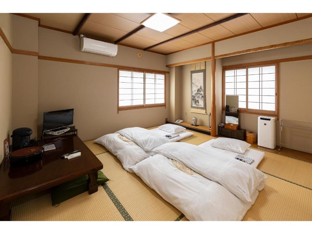 Pokój z 3 łóżkami, biurkiem i oknami w obiekcie Business Hotel Katsuya - Vacation STAY 62209v w mieście Wakayama
