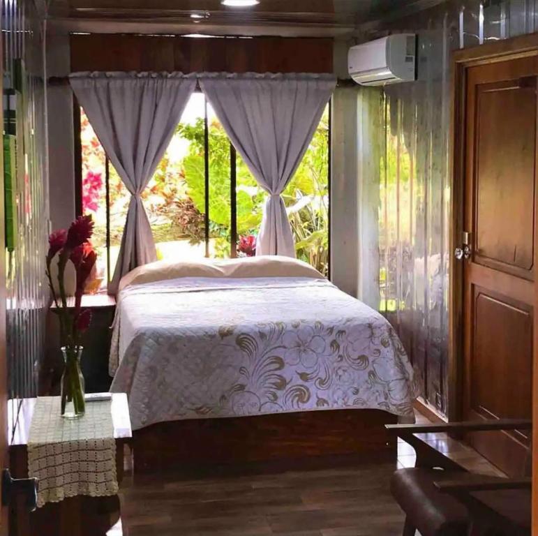 1 dormitorio con cama y ventana en Cabin in La Fortuna : Ceiba Eco Container, en Fortuna