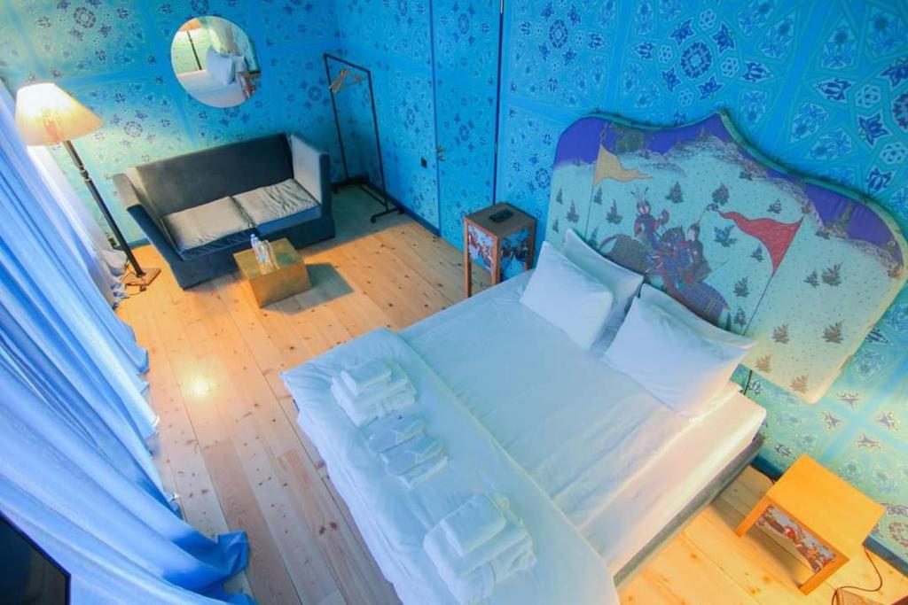 1 dormitorio con 1 cama grande en una habitación con paredes azules en Erekle II en Telavi