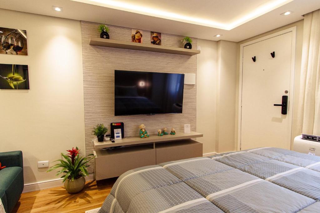 um quarto com uma televisão de ecrã plano na parede em Belvedere em Curitiba