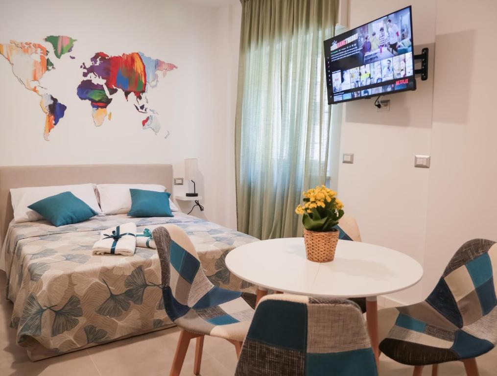 Schlafzimmer mit einem Bett, einem Tisch und Stühlen in der Unterkunft Liv it - Guest House in Bari