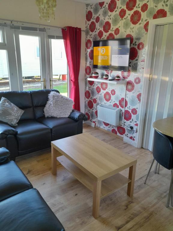 a living room with a couch and a coffee table at B8 lovely chalet in Mablethorpe