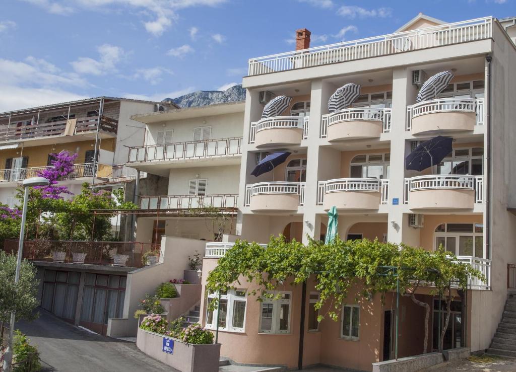un edificio de apartamentos con balcones y árboles en Apartments Kovač, en Makarska