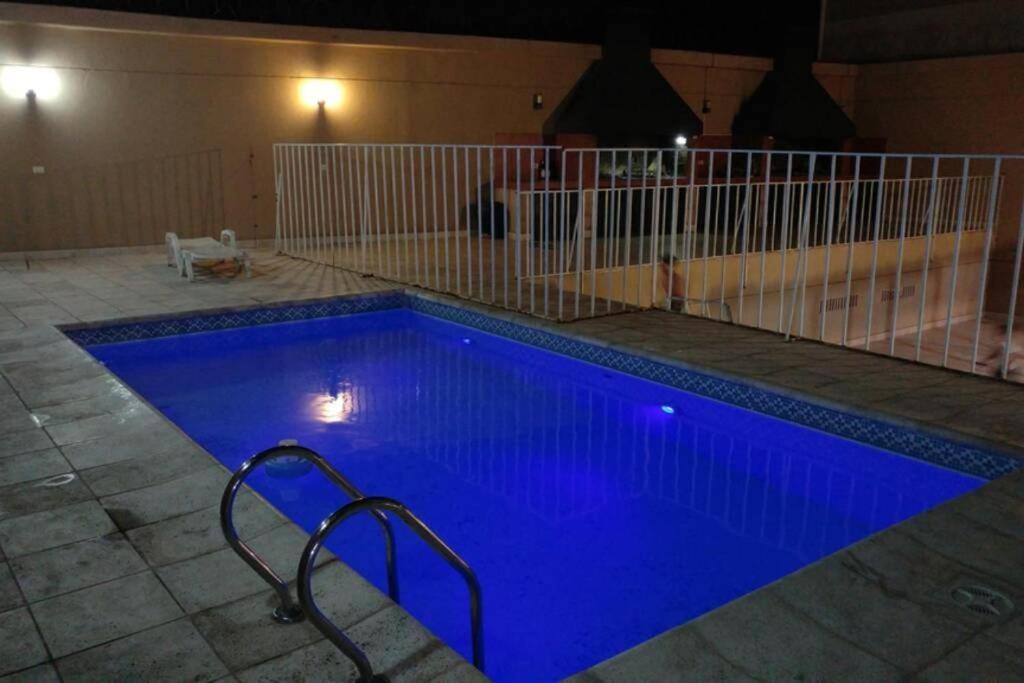 una gran piscina con iluminación azul en un edificio en Departamento a 1 cuadra de calle Aristides en Mendoza