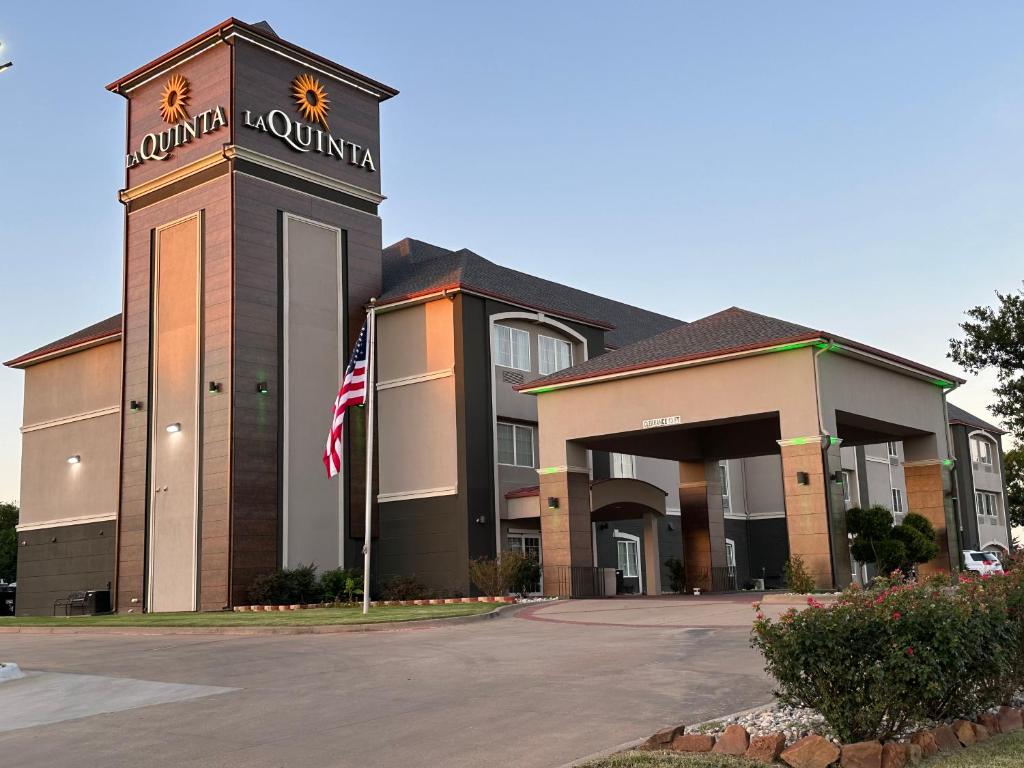 ein Gebäude mit amerikanischer Flagge davor in der Unterkunft La Quinta by Wyndham Sulphur Springs in Sulphur Springs