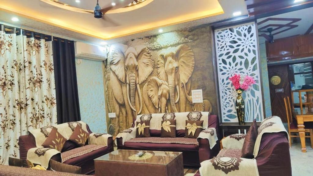 a living room with couches and a mural of elephants at Luxurious 3 BHK Flat in Ghaziabad in Ghaziabad