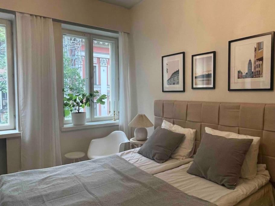 a bedroom with a large bed and two windows at Central lux location, self check-in, ensuite with full kitchen in Helsinki