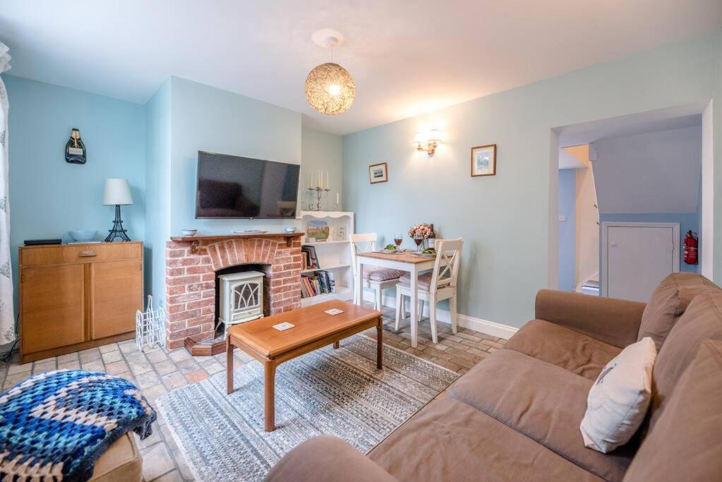 a living room with a couch and a fireplace at No. 10, The Cottage in Framlingham