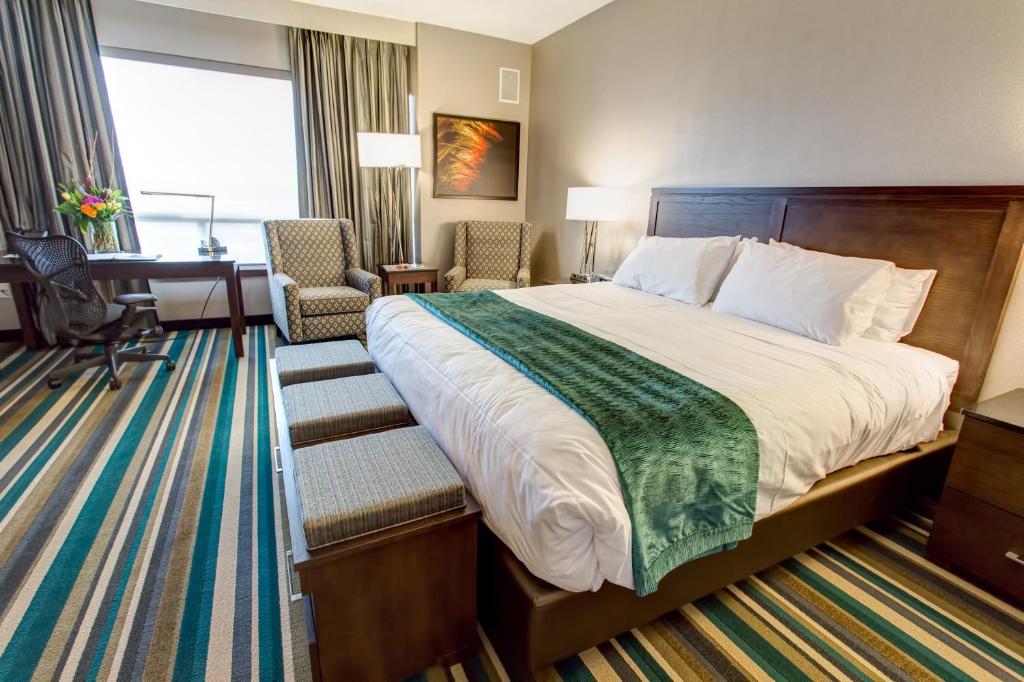 um quarto de hotel com uma cama grande e uma secretária em Hotel Blackfoot em Calgary