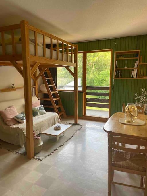 a room with a bunk bed and a table at Studio près du lac in Malbuisson