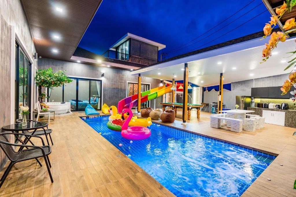uma piscina interior com escorrega e uma sala de jogos em White Cloud & Brown Sand Luxury Pool Villa Cha-Am em Cha Am