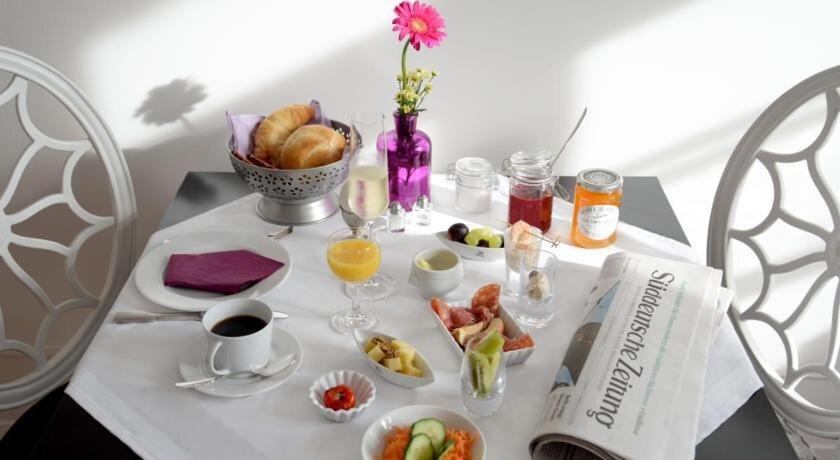 a table with breakfast foods and drinks on it at Alte Apotheke Bed & Breakfast in Karlsbad