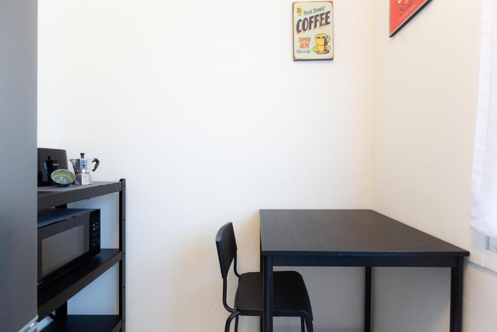 a black table with a black chair next to a wall at Carola's place - by Relais Di Giada in Como