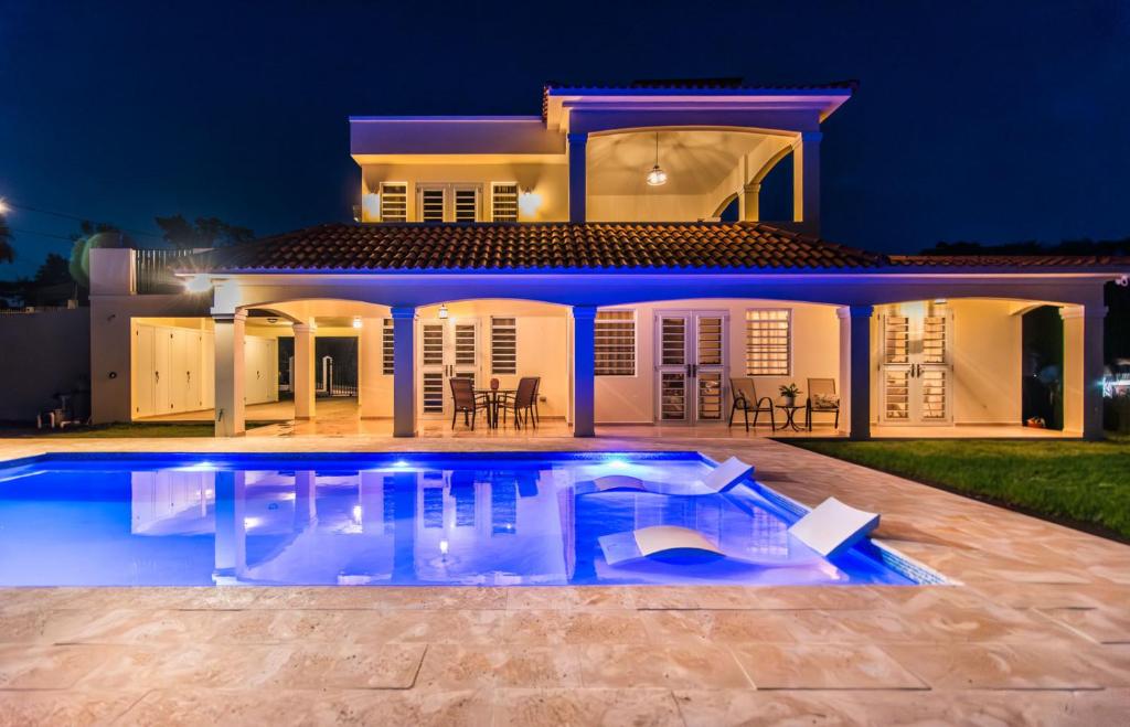 a villa with a swimming pool at night at Casa Cielo in Rincon