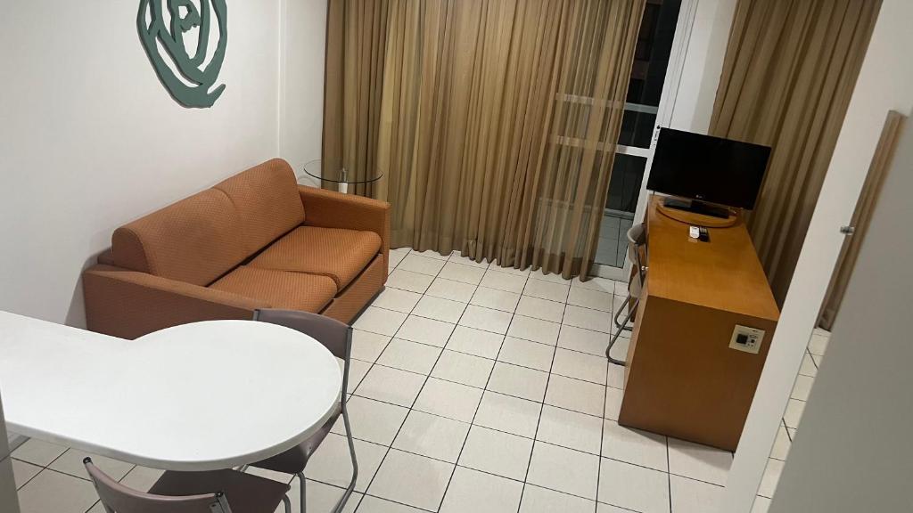 ヴィトーリアにあるPraia do Canto Apart Hotel quarto sala e varanda andar altoのソファとテーブルのあるリビングルーム