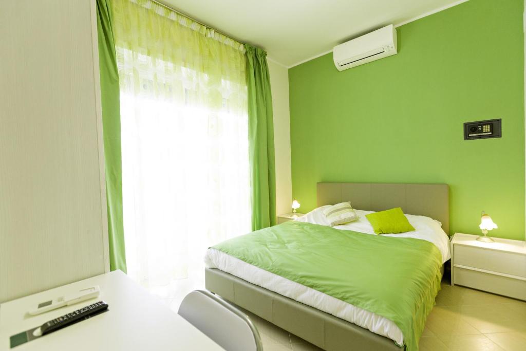 a green bedroom with a bed and a window at B&B il Giglio Marino in Gaeta