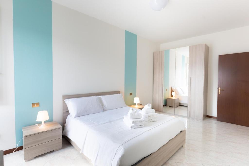 a bedroom with a large white bed with towels on it at Carola's place - by Relais Di Giada in Como
