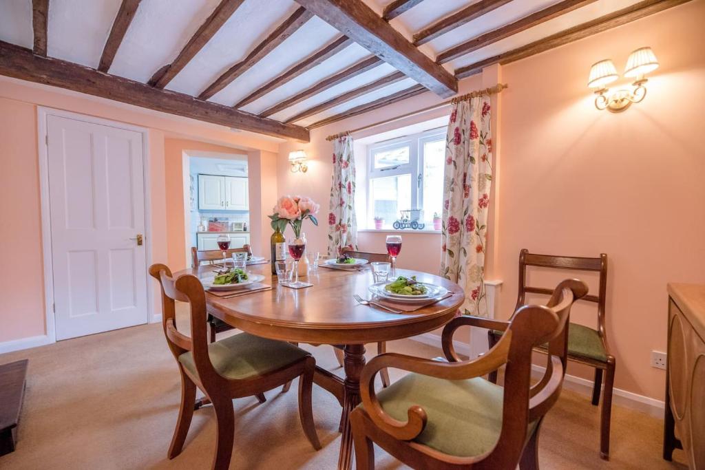 a dining room with a wooden table and chairs at The Old Shop, No 12 in Framlingham