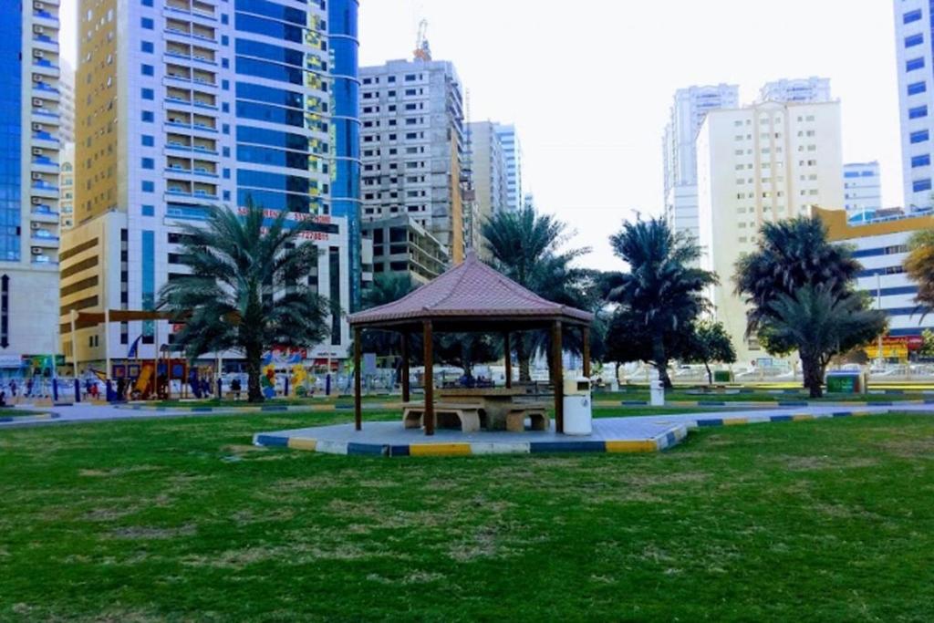a park with a gazebo in the middle of a city at Affordable Comfort: Cozy Room with Dedicated Bath & Twin Beds in Sharjah