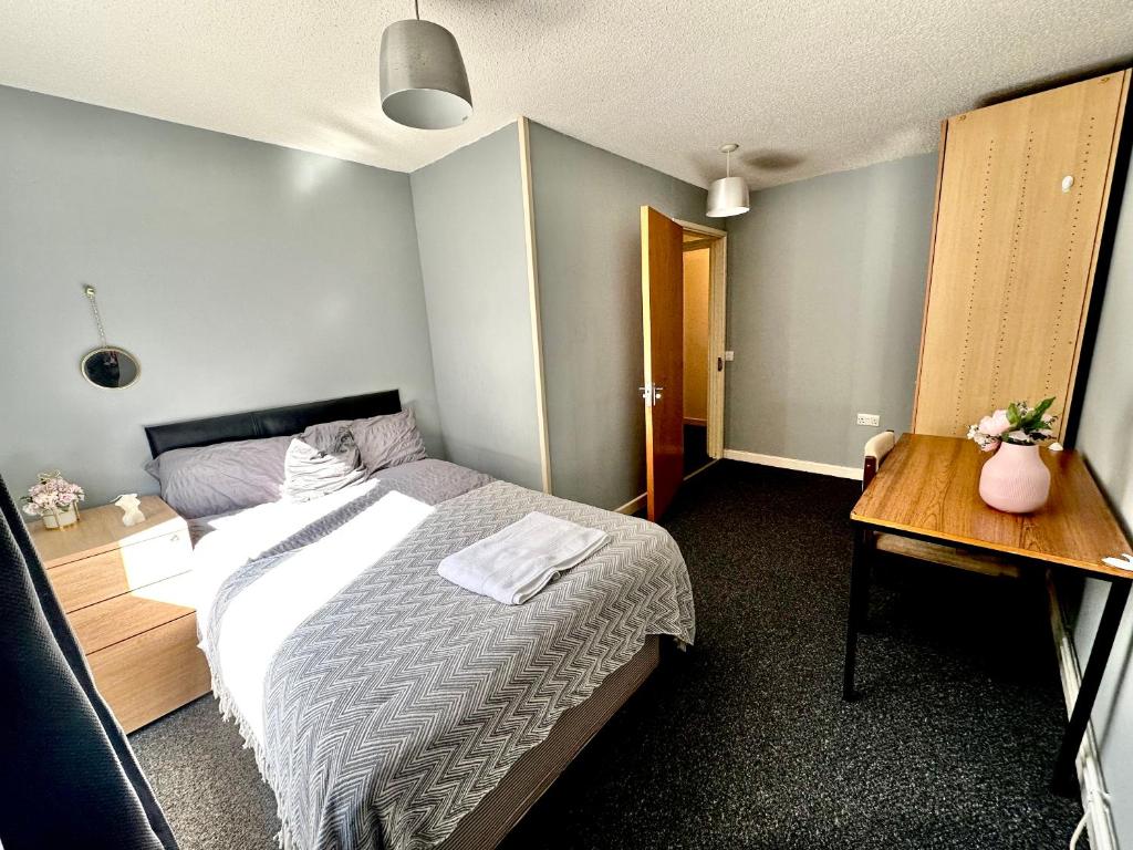 um quarto com uma cama e uma mesa de madeira em Station Court em Swansea
