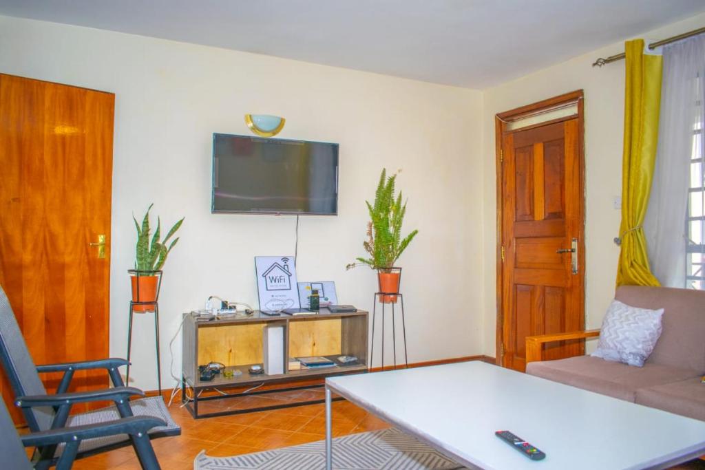 sala de estar con sofá y TV en Zani Suites, en Nakuru